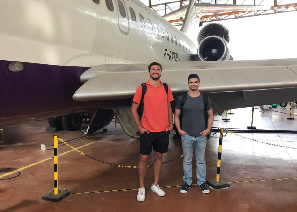 Will Mnich (left) poses with his friend at the airplane hangar © Will Mnich