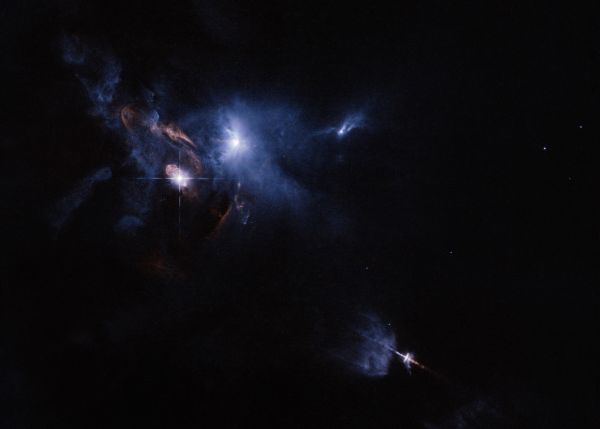 Photo : Vue élargie de la région du nuage moléculaire du Taureau. HL Tauri est enveloppée dans la région bleue brillante située en haut à gauche de l'image. © ESA/NASA Hubble